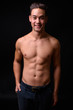 © Ranta Images - Young handsome multi ethnic man shirtless against black background