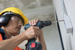 © khwanchai - worker unscrew on wall by screwdriver
