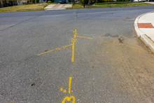 Yellow Markings On An Asphalt Street That Show Where The Utility Lines Are Berried So That They Can Be Avoided If The Road Is Dug Up For Repairs