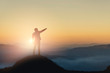 Silhouette of businessman on mountain with sunset sky background. Business success and leadership concept.