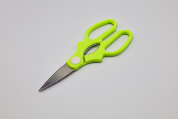 top view of a pair of green colored plastic open scissors isolated on white background
