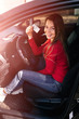 © Ivan - Teenage girl with her driver's license driving a new.
