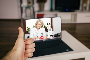 Poster - Telemedicine positive concept. Showing thumbs up to a doctor GP on a computer screen, living room home background