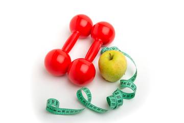 Bright apple and red dumbbells with a Measuring tape on a white background