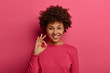 Portrait of satisfied Afro American woman shows okay gesture, says excellent, announces good news, likes product and guarantees best quality, smiles positively, gives advice and likes choice