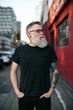 © Rob and Julia Campbell/Stocksy - Fashionable, smiling bearded man hanging out downtown alone