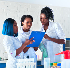 Three young African female medtech, doctors, physicians discuss case medical history, pcr testing and antibody test results of patients with pneumonia COVID-19 caused by novel coronavirus