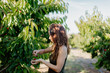 © Javier Pardina/Stocksy - Young couple picking cherries in the field at summer.