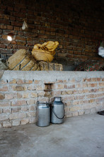 Rural Milk Cans Made Of Steel In Front Of Bricked Wall