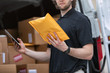 © Sean Locke Photography/Stocksy - Shipment: Man Confirms Envelope Is Correct One