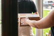 © Sean Locke Photography/Stocksy - Shipment: Man Hands Box To Homeowner