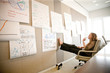 © Jon Feingersh - Businesswoman looking at charts while sitting on chair in office