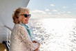 © Gillian Vann/Stocksy - Side view of smiling senior woman on cruise
