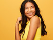 © leandro crespi/Stocksy - Asian Woman fun portrait Smiling isolated over Yellow Studio Background