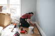 © Rob and Julia Campbell/Stocksy - Young woman painting house trim inside.