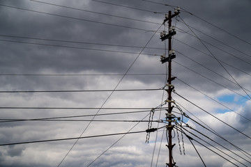 Power lines. Electricity on a roof. Clouds on the background