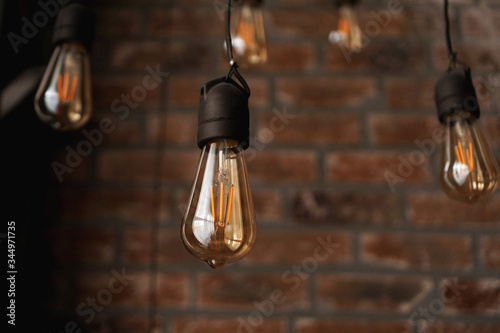 Cuadros en Lienzo Decorative antique edison style light tungsten bulbs against brick wall backgrou