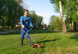 © Small365 - The worker mows the grass using a trimmer image,maintaininig the greenery