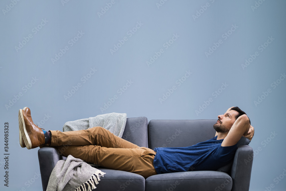 Man Relaxing On Sofa At Home - obrazy, fototapety, plakaty 