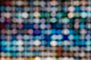 Wall Mural - Blurred colorful LED illuminated bokeh background on Grid frame arrangement system. Abstract defocused illuminated backdrop with light bokeh on rectangular grid pattern dispaly.