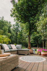 Classy furniture on wooden terrace in green beautiful garden