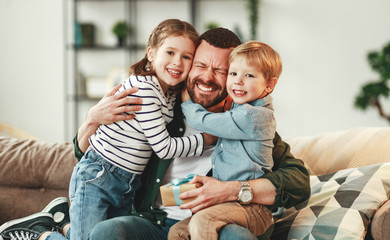 Wall Mural - little siblings congratulating happy father at home.