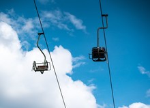 Low Angle Shot Of Cable Cars With A Cloudy Blue Sky In The Background