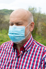 Wall Mural - Senior man with surgical mask outdoors