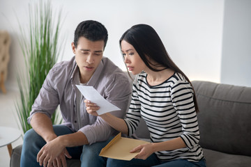 Young woman and man reading an open document.