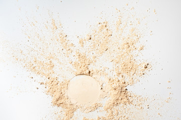 Whitening Mineral Loose Powder.Scattered tan colored facial loose powder on white background.