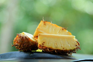 Wall Mural - Sliced pineapple in the banana leaf isolated on blended green background