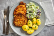Chop pork cutlets , served with boiled potatoes and salad.