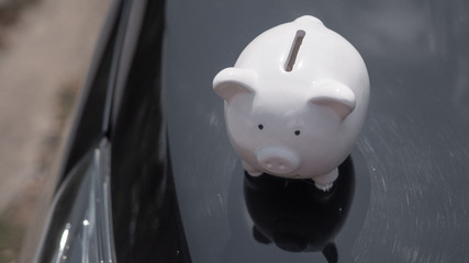 Piggy standing on the black colour car background, Saving money to loan for car concept