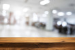 © qOppi - Empty wooden table and blurry background of white bokeh light department store for product display montage.