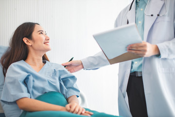 Wall Mural -  Medicine and health care concept.  Asian doctor is taking care patient woman in hospital.doctor or nurse wear protection mask checking and takecare infection people from covid-19 .