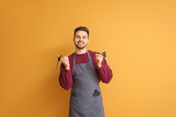 Male hairdresser on color background