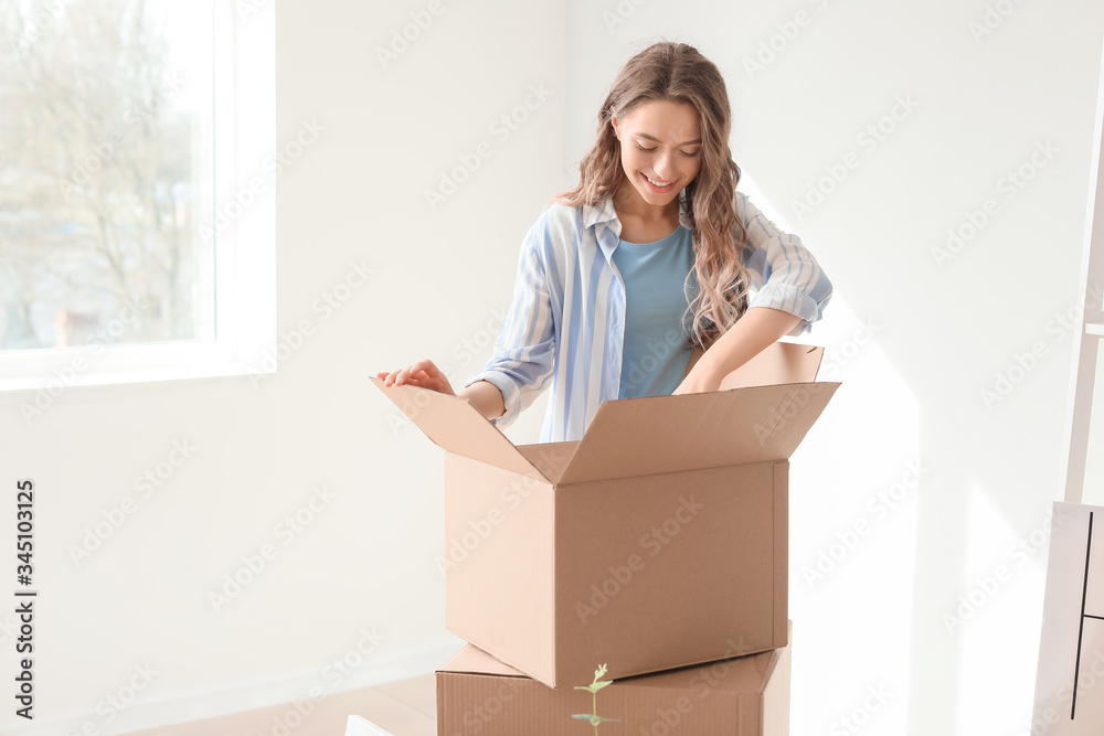 Young woman with moving boxes in her new home