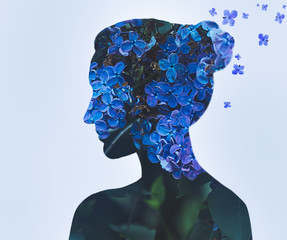 Woman portrait with double exposure and with flowers of blue lilac closeup