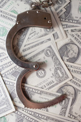 handcuffs sitting on top of US paper currency