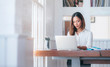 © NAMPIX - Portrait of young asian woman working with laptop at home office.