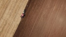 A Redder Tractor Plows A Field