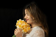 Close Up portrait of an attractive young woman holding a bouquet isolated on a black background