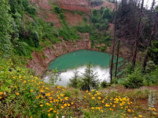 Flower glade on side of karst lake Sea Eye or Morskoy Glaz, village Shariboksad, Mari El Republic, Russia. Name of lake inspired by sea-like colour of water. Depth of lake more than 120 feet