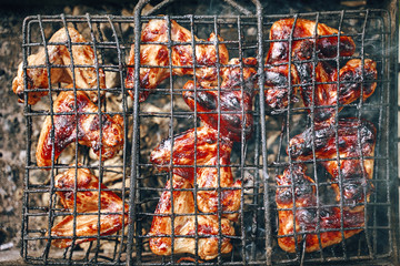 Delicious grilled meat chicken legs over the coals on a barbecue. Flat lay Top view