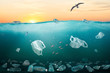 Environmental problem with plastic pollution in ocean illustrated by sunrise over sea full of plastic bottles and plastic bags.
