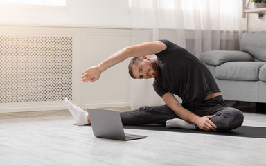 Active man practicing sports training online on laptop