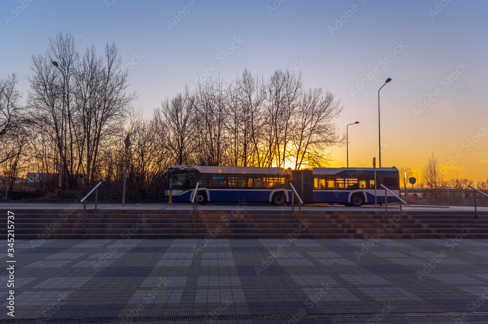 Biało-niebieski, krakowski autobus miejski podczas zachodu słońca. - obrazy, fototapety, plakaty 