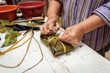 © Quiony Navarro/Wirestock - Selective focus shot of preparing Casava Suman in a banana leaf