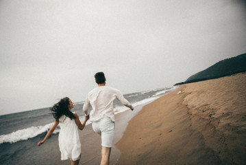 Wall Mural - 
Happy lovers have a cheerful vibes on sea beach at sunset 
