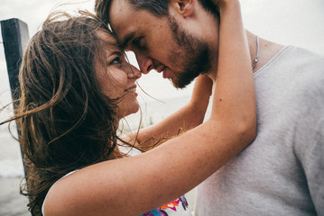 Wall Mural - Happy lovers have a cheerful vibes on sea beach at sunset 